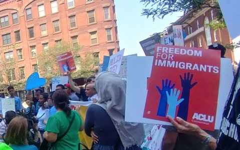 Photo of crowd at Hartford rally, including red ACLU of Connecticut sign that says "freedom for immigrants"