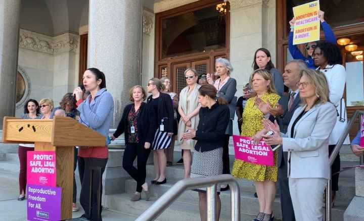 ACLU-CT speaks at abortion access rally in Hartford. Signs say "abortion is healthcare, abortion is a right" and "protect safe, legal abortion."