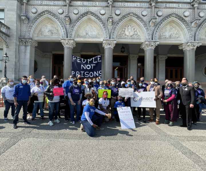 Group photo in front of the capitol after the Clean Slate press conference. A people not prisons sign can be seen.