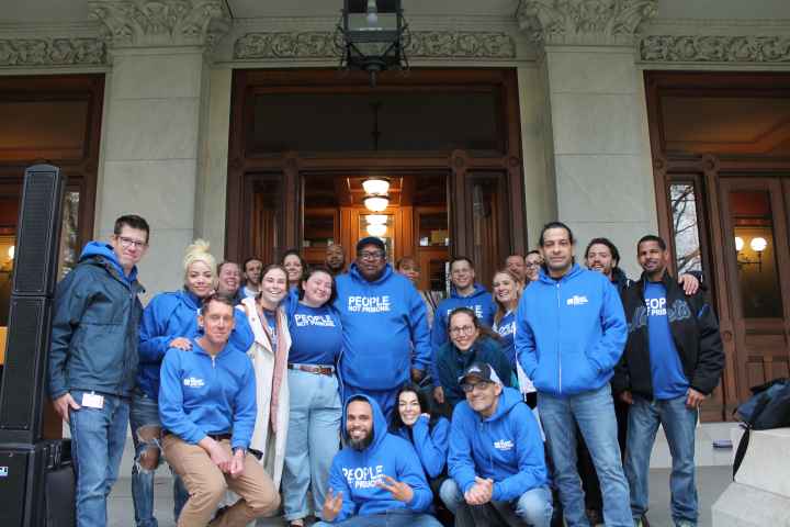 Smart Justice leaders and ACLU staff are standing in front of the capitol smiling at the camera.