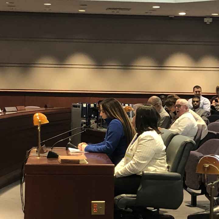 Ciara Rosati, Smart Justice leader, testifies in support of strong Clean Slate, SB 403, at the CT General Assembly in 2020. Ciara wears a blue shirt and is seated next to policy counsel Kelly Moore, in a white blazer.