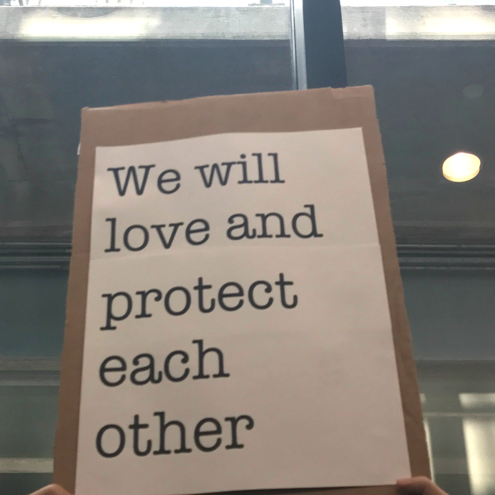 We will love and protect each other sign at Bradley Airport protest against Trump Administration's Muslim ban
