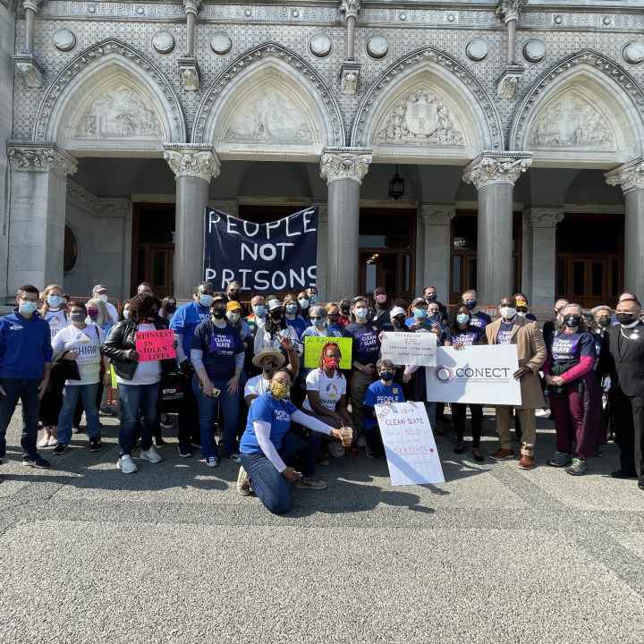 Group photo in front of the capitol after the Clean Slate press conference. A people not prisons sign can be seen.