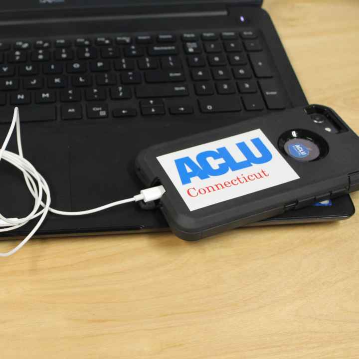 ACLU of Connecticut photo of laptop, phone, headphones with an ACLU of Connecticut sticker