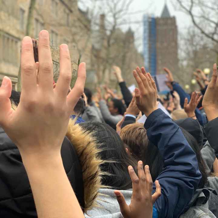 Photo of people with hands raised.