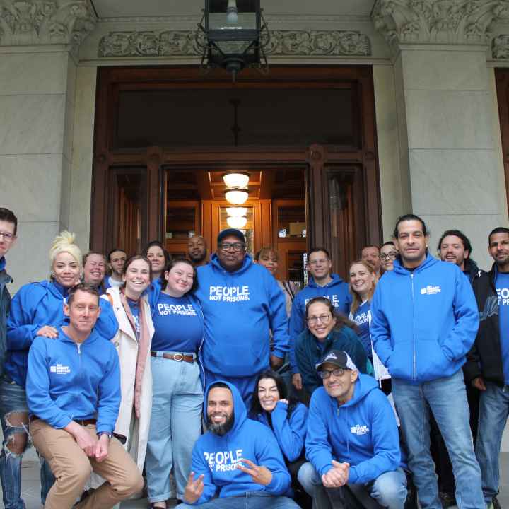 Smart Justice leaders and ACLU staff are standing in front of the capitol smiling at the camera.