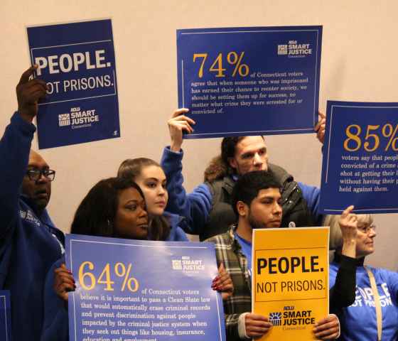 ACLU-CT Smart Justice leaders stand with "people not prisons" posters at a Connecticut Clean Slate pres conference